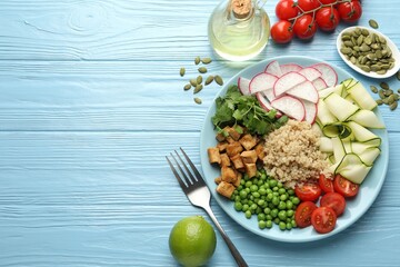 Different healthy vegetarian food served on light blue wooden table, flat lay. Space for text