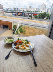 Elegant morning meal showcasing crispy eggs vibrant salad and tangy slaw served beside large window urban backdrop