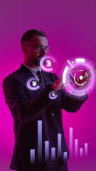 Businessman in a suit using futuristic interface with glowing finance symbols on pink background....