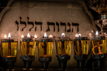 Flickering flames of burning Hanukkah candles inside a glass housing during the celebration of the Festival of Lights in Jerusalem, Israel.