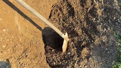 A large pile of sand, gravel, and a shovel for mixing concrete and building paving stones or...