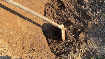 A large pile of sand, gravel, and a shovel for mixing concrete and building paving stones or...