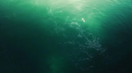 Emerald Green Water Surface Ripples with Sunlight Reflections and Dark Depths Abstract View