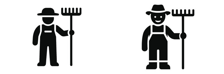 Farmer in overalls holding a rake is working in a rural field during daylight hours