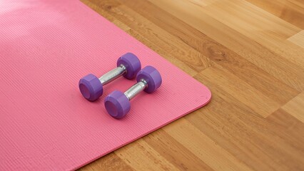 Wooden floor with dumbbells and a yoga mat