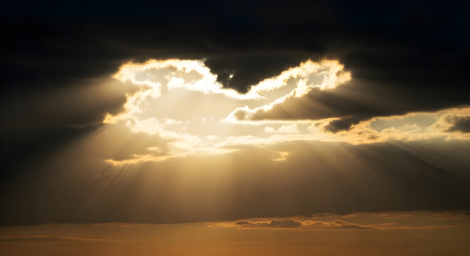 Dramatic Sky with Golden Sunlight Streaming Through Dark Storm Clouds