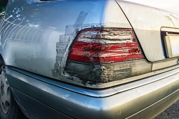 Broken taillight on car and sealed with transparent tape. Broken car stop signal repaired with...