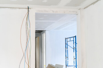 Interior renovation reveals gypsum board ceiling and wall smooth edges showing electrical wire...