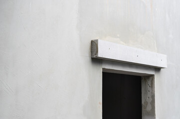 Minimal white wall during house renovation project shows concrete lintel over an opening....