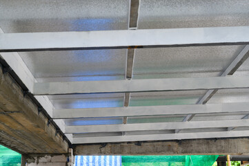 Construction view showing metal beams supporting thermal panels. Lightweight pu foam fills each sheet providing energy efficiency for roof ceiling structure