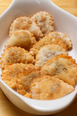 Delicious portion of fried pastries served in a white ceramic bowl on a wooden table.
