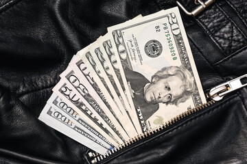 Dollar bills in leather pocket. Stack of US money in black zipper pouch. Cash hiding in jacket....