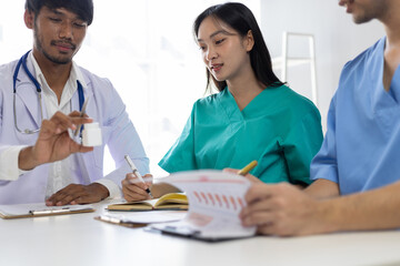 Fototapeta premium Medical team discussing treatment plan during meeting, analyzing data and prescriptions in hospital, discuss the analysis of documents from trials on the efficacy of a new drug.