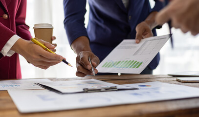 Business people analyzing financial documents, discussing charts and graphs showing company growth...