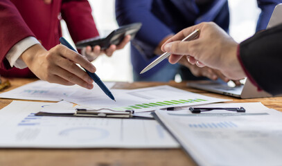 Business people analyzing financial documents, discussing charts and graphs showing company growth...