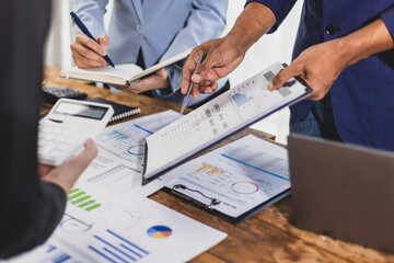 Business people analyzing financial documents, discussing charts and graphs showing company growth...