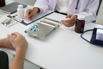 Doctor preparing prescription drugs for patient in clinic. Female doctor counting and prepare...