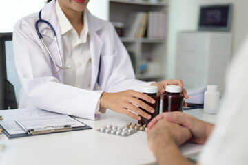 Female doctor explaining medicine dosage to patient during appointment in medical clinic. Health...