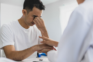 Doctor talking with stressed patient in hospital. Physician is comforting a patient and counseling...