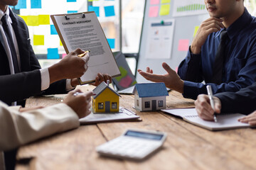 Real estate agents are presenting contract agreements and discussing housing projects with clients.