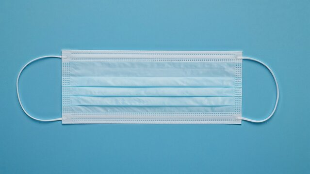 Protective medical face masks against viruses and bacteria on a blue backdrop. - Powered by Adobe