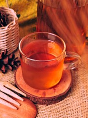 Warm Herbal Tea in Glass Cup with Rustic Autumnal Still Life.