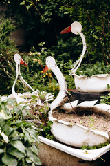 Painted swan sculptures made from tires, outdoor upcycling decoration.