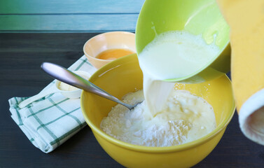 Adding hot milk onto the mixtures for baking Brazilian cheese bread called Pao de Queijo