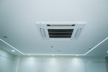 Ceiling-mounted air conditioner with integrated light and speaker, showcasing modern HVAC design..