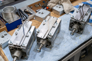 V&eacute;rins hydrauliques pos&eacute;s sur un &eacute;tabli dans un atelier, entour&eacute;s d&rsquo;outils et de composants m&eacute;caniques, &eacute;voquant un environnement industriel technique.