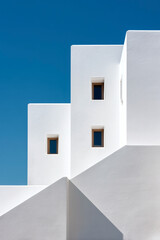 Geometric White Architecture: stark white walls with sharp angles against a clear, bright blue sky background.