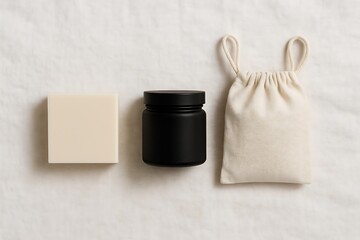 A minimalist flat lay of skincare products including a white soap bar a black jar and a beige drawstring pouch on a