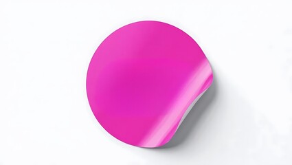 A pink round sticker with a curled edge on a white surface creating a minimalist composition view