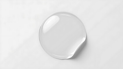 A simple white round sticker peeling off from a white surface in a minimalistic composition style