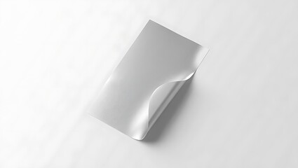 A white sheet of paper with a curled corner on a white background in a studio setting close up view