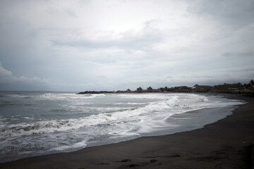 Waves Crashing on Beach with Cloudy Sky and Sandy Shore