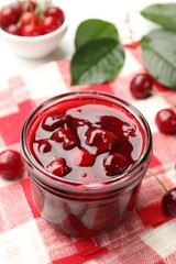 Tasty cherry jam and fresh fruits on white table, closeup
