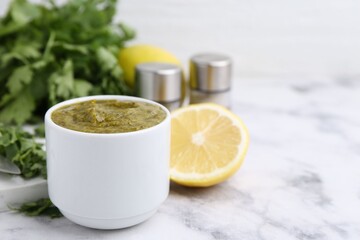 Tasty sauce with cilantro and other ingredients on white marble table, closeup. Space for text