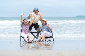 Happy senior women enjoying a playful walk on the beach, laughing and holding hands