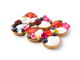 Sweet tartlets with berries and flowers isolated on white. Delicious dessert