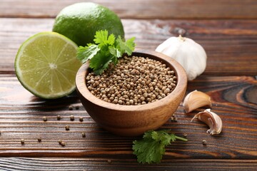 Coriander seeds, fresh cilantro, lime and garlic on wooden table, closeup