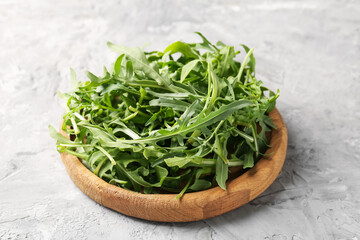 Fresh ripe green arugula leaves on grey table, closeup