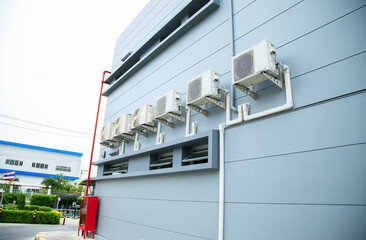 Condenser unit or compressor outside home or residential building. Unit of central air conditioner AC or heating ventilation air conditioning system HVAC. Electric fan and refrigerant pump inside.