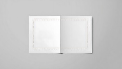Open blank book lying flat on a gray surface with a subtle border around the pages creating a mockup