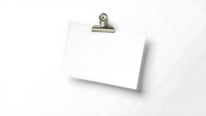 A blank white card held by a silver clip against a clean white background in a studio shot