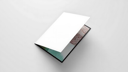 Open invitation card with white blank paper and decorative silver pattern on a white surface