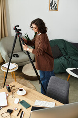 Young woman with curly hair captures moments in her cozy home workspace