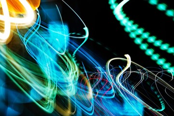 The image is a blurry, colorful, and dynamic representation of light and movement. The various colors and shapes create a sense of energy and excitement
