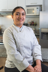 Smiling young chef posing in the restaurant kitchen