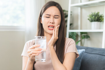 Suffering from toothache, hurt asian young woman touch cheek, face expression ache or feel pain,...